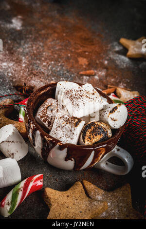 Anno nuovo, dolcetti di Natale, dolci. Tazza di cioccolata calda con marshmallow fritto, ginger star cookies, uomini di panpepato, striped candy, spezie cannella Foto Stock