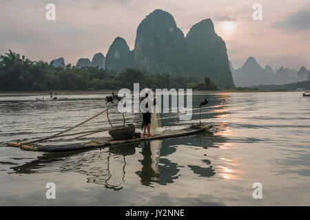 Cormorano pescatore al tramonto, il fiume li, xinping, Yangshuo, Cina Foto Stock