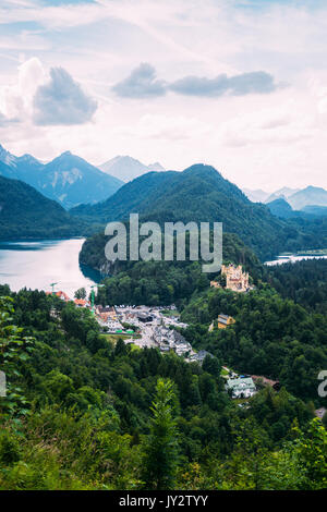 Panorama sulle Alpi e Alpsee lago di montagna con Hohenschwangau e il suo castello in primo piano. Foto Stock