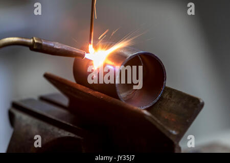 La saldatura, con una torcia di saldatura di due tubi di metallo vengono saldate, seminario di formazione per riscaldamento e idraulici artigiani, Foto Stock