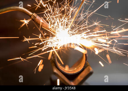 La saldatura, con una torcia di saldatura di due tubi di metallo vengono saldate, seminario di formazione per riscaldamento e idraulici artigiani, Foto Stock