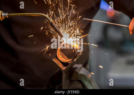 La saldatura, con una torcia di saldatura di due tubi di metallo vengono saldate, seminario di formazione per riscaldamento e idraulici artigiani, Foto Stock