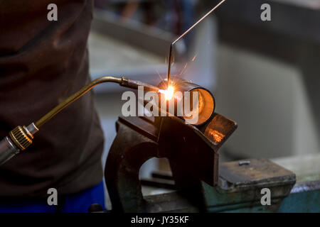 La saldatura, con una torcia di saldatura di due tubi di metallo vengono saldate, seminario di formazione per riscaldamento e idraulici artigiani, Foto Stock