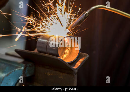 La saldatura, con una torcia di saldatura di due tubi di metallo vengono saldate, seminario di formazione per riscaldamento e idraulici artigiani, Foto Stock