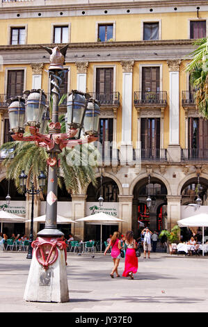 Tavoli da caffe' all'aperto fieggiano la Plaza Reial nel Barri Gotic di Barcellona, Spagna durante l'estate. Foto Stock