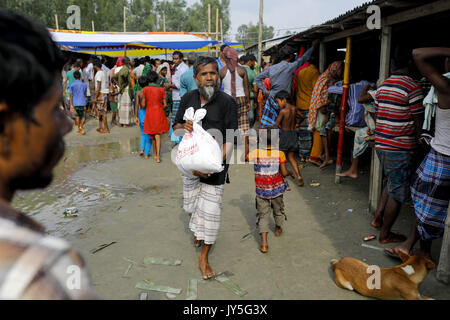 Agosto 17, 2017 Bogra, Bangladesh. 17 Ago, 2017. Alluvione del Bangladesh colpite gli uomini ricevono sollievo da un locale rulling parte MP a Jamtola, Sariakandi, Bogra. Secondo le autorità, inondazioni causate dalle forti piogge rizzatura Bangladesh durante la scorsa settimana hanno lasciato almeno 56 morti. Le persone colpite sono in attesa di ottenere più rilievo come essi sono in carenza di cibo e di acqua potabile nei centri di ricovero. Credito: K M Asad/ZUMA filo/Alamy Live News Foto Stock