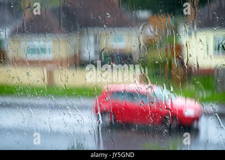 Chippenham, Regno Unito, 18 agosto 2017. Come le perturbazioni atmosferiche continua nel Regno Unito, un pilota di auto in Chippenham è raffigurato attraverso un vetro ricoperto con gocce di pioggia come loro guida nel centro della città nel corso di un pesante con doccia a pioggia. Credito: lynchpics/Alamy Live News Foto Stock