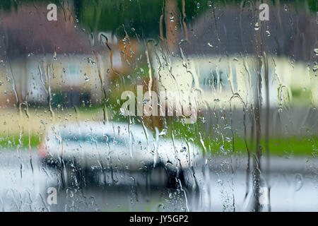 Chippenham, Regno Unito, 18 agosto 2017. Come le perturbazioni atmosferiche continua nel Regno Unito, un pilota di auto in Chippenham è raffigurato attraverso un vetro ricoperto con gocce di pioggia come loro guida nel centro della città nel corso di un pesante con doccia a pioggia. Credito: lynchpics/Alamy Live News Foto Stock