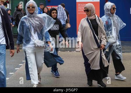 Londra, Regno Unito. 18 Agosto, 2017. I turisti in Piccadilly Circus catturati in una luce doccia a pioggia a Londra. Credito: claire doherty/Alamy Live News Foto Stock