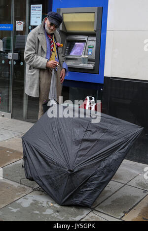 Knightsbridge. Londra, Regno Unito. 18 Agosto, 2017. Persone riparo sotto un ombrello da pioggia in Knightsbridge. Credito: Dinendra Haria/Alamy Live News Foto Stock