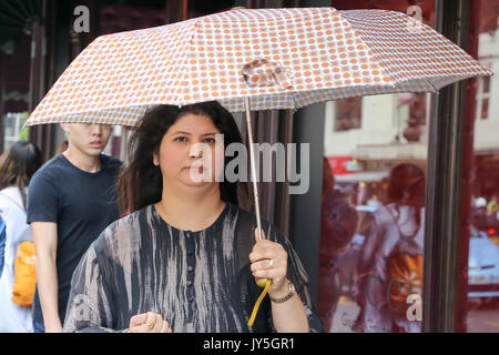 Knightsbridge. Londra, Regno Unito. 18 Agosto, 2017. Persone riparo sotto un ombrello da pioggia in Knightsbridge. Credito: Dinendra Haria/Alamy Live News Foto Stock