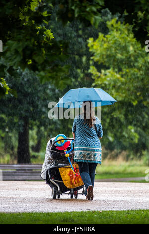 Londra, Regno Unito. Il 18 agosto 2017. Un forte acquazzone le catture della gente fuori sul Clapham Common ma presto passa e il sole ritorna. Londra 18 ago 2017. Credito: Guy Bell/Alamy Live News Foto Stock