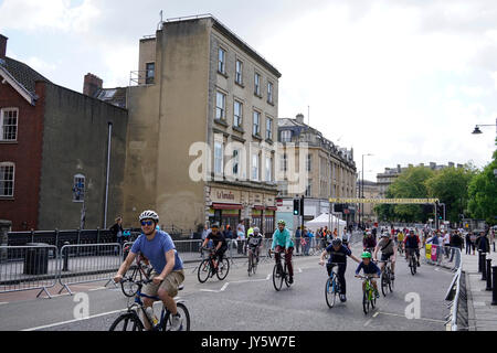 Bristol, Regno Unito, 19 agosto 2017. I ciclisti di piacere passare un Banksy murale (sullo sfondo a sinistra) come provano il corso per il Bristol Grand Prix precedendo la gara principale. "L amore la vostra moto' evento ciclisti ha dato la possibilità di assaggiare il percorso, partendo in Park Street, per una quota di iscrizione di € 1,50 con proventi di andare a Bristol il cancro West paziente giovane appello. Il Grand Prix del sabato è seguita la domenica da HSBC Regno Unito città in bicicletta per famiglie a Bristol il parco del castello. Credito: mfimage/Alamy Live News Foto Stock