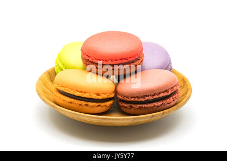 Macarons nel piatto di legno su sfondo bianco Foto Stock