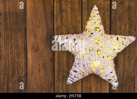 Rattans bianco splendente stella di Natale su weathered plank Sfondo legno, copiare lo spazio per testo, modello per biglietto di auguri, poster Foto Stock