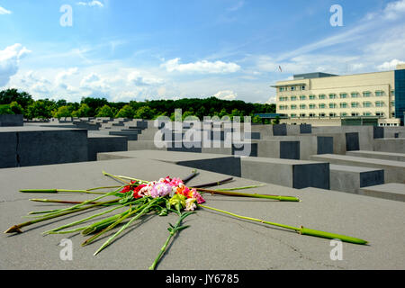 Un mazzo di fiori a sinistra al Memoriale dell Olocausto a Berlino, con l'ambasciata americana in background. Foto Stock