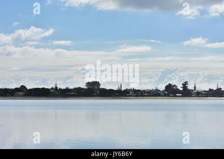 Le case si riflette nell'acqua clam di Tairua Harbour Foto Stock