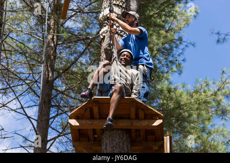 MEZIO, Portogallo - 22 luglio 2017: uomo avventuroso si prepara a una diapositiva in zip fodera attraverso la foresta. Luglio 22, 2017, Mezio, Portogallo. Foto Stock