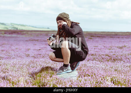 Fotografo Barbuto con Dreadlocks prende Fotografia con telemetro Vintage fotocamera Foto Stock