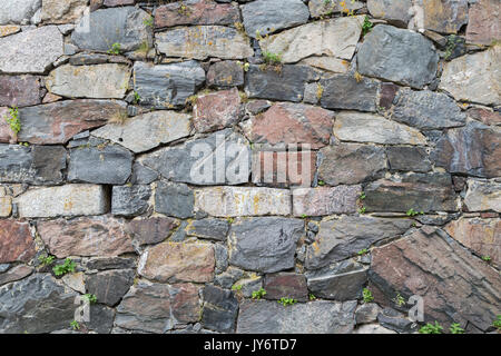 Close-up di un vecchio muro di cinta in una fortezza fatta di pietre. Foto Stock