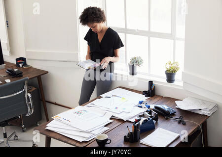 Giovane imprenditrice in ufficio guardando il diario, angolo alto Foto Stock