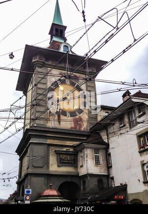 Vista del pubblico il sovraccarico del tram le linee di filo di fronte al famoso Zytglogge medievale orologio Astronomico Torre nel centro della città vecchia di Berna, Switzerl Foto Stock