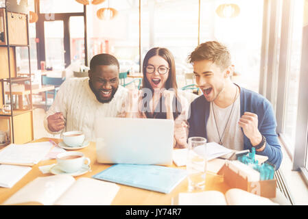 Overjoyed gli studenti internazionali in seduta il cafe Foto Stock