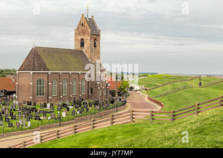 Wierum, con i suoi 11th-centuy chiesa al di sotto di una diga sul mare di Wadden nella provincia della Frisia, Paesi Bassi. Foto Stock