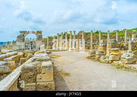 I siti di antiche città anatolica di Perge - il canale d'acqua, Arco di Apollonio e la fila di colonne di marmo, Antalya, Turchia. Foto Stock