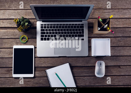 Vista aerea di gadget elettronici e delle forniture di ufficio su un tavolo di legno Foto Stock