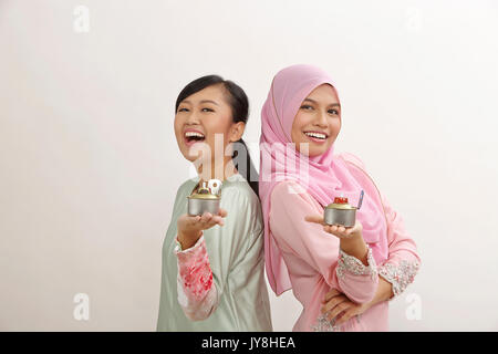 Due donne Malay holding olio lampada o pelita Foto Stock