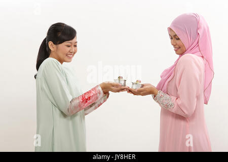 Due donne Malay holding olio lampada o pelita Foto Stock