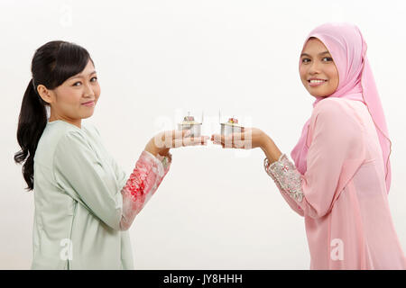 Due donne Malay holding olio lampada o pelita Foto Stock