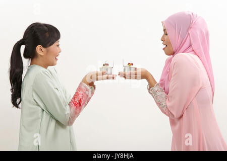 Due donne Malay holding olio lampada o pelita Foto Stock