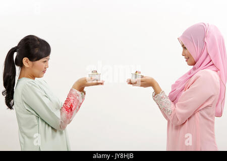 Due donne Malay holding olio lampada o pelita Foto Stock