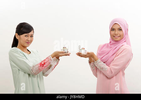 Due donne Malay holding olio lampada o pelita Foto Stock