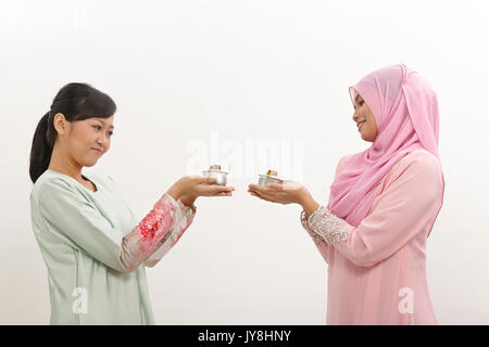 Due donne Malay holding olio lampada o pelita Foto Stock