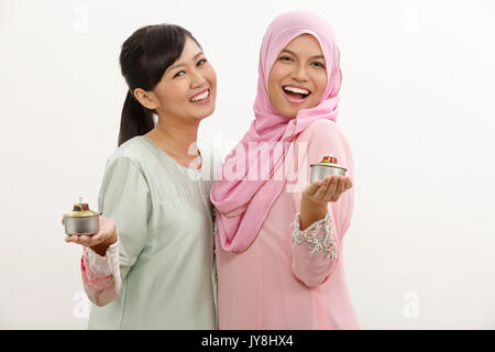 Due donne Malay holding olio lampada o pelita Foto Stock