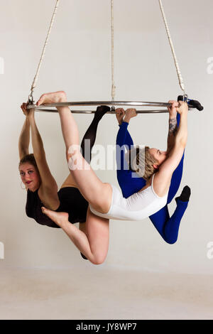 Giovane donna di trio facendo som acrobatici volteggi sull'antenna di lucentezza Foto Stock