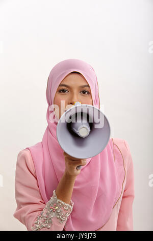 Donna malay parlando in un megafono facendo un annuncio pubblico isolato su bianco Foto Stock