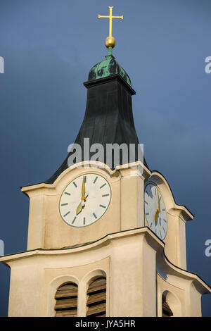 Antica e storica torre campanaria campanile con orologio antico e croce dorata sulla sommità della chiesa Foto Stock