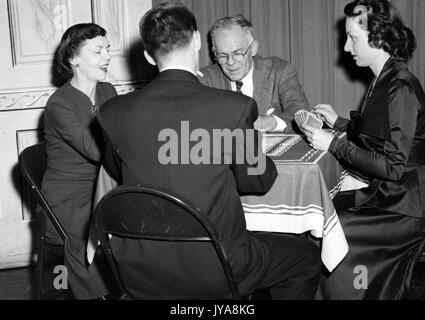 Quattro individui seduti intorno ad un tavolo per giocare a carte per 'la verità circa la guerra biologica' segmento della Johns Hopkins science review show televisivo, maggio 1951. Foto Stock