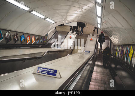 Pendolari su una scala mobile in una stazione della metropolitana di Londra (UK). Giugno 2017. Formato orizzontale. Foto Stock