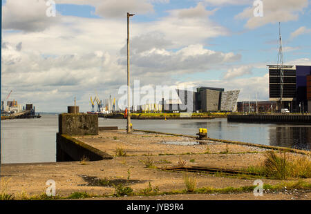 Il fiume Lagan a Belfast tra cui la mitica Titanic centro da uno dei dismessi ferry terminal rampe di carico su Donegall Quay Foto Stock