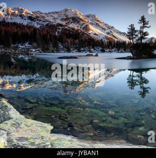 Autunno riflessi al Lago Saoseo ancora parzialmente congelato valle di Poschiavo Cantone dei Grigioni Svizzera Europa Foto Stock