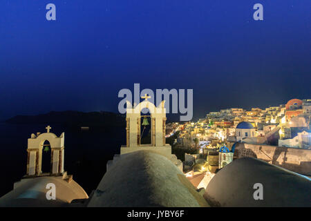 Vista notturna di Oia con il bianco chiese e case e sul blu del Mar Egeo come simboli di Grecia Santorini Cyclades Grecia Europa Foto Stock