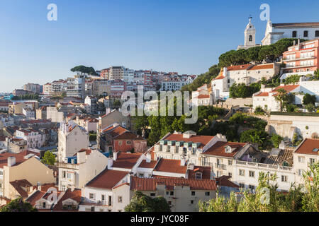 Vista di un quartiere residenziale di Lisbona circondato da alberi e la chiesa sotto un cielo di estate blu Portogallo Europa Foto Stock