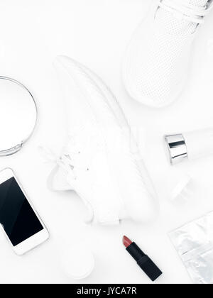 Bianco scarpe sportive con donne accessori su sfondo bianco Foto Stock