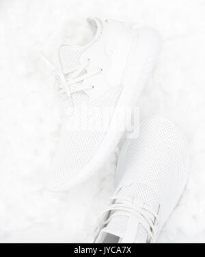 Bianco scarpe sportive su cotone sfondo bianco Foto Stock
