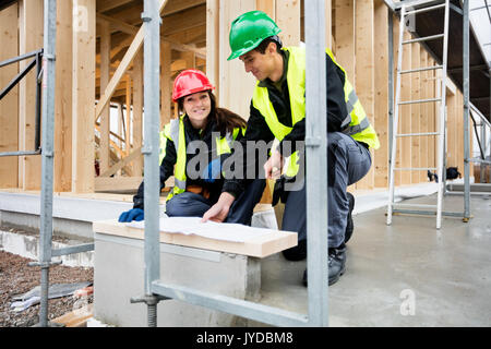 Architetto femmina sorridere mentre seduta dal collega al sito Foto Stock